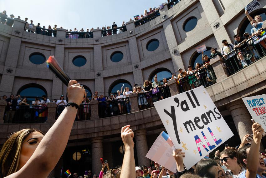 People line the railing on all three levels of the outdoor rotunda of the state Capitol in Austin, and wave signs during the "Fight for our Lives" rally in opposition of anti-LGBTQ bills on March 27, 2023.