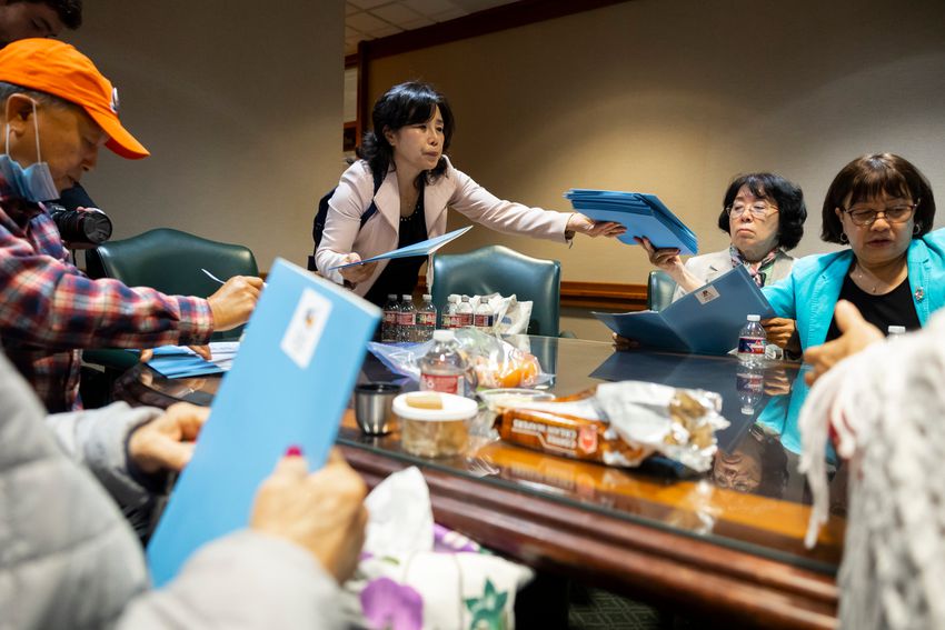 Woori Juntos Service Coordinator Si Hwa Gi hands out information packets about speaking with lawmakers on Tuesday, April 25, 2023.