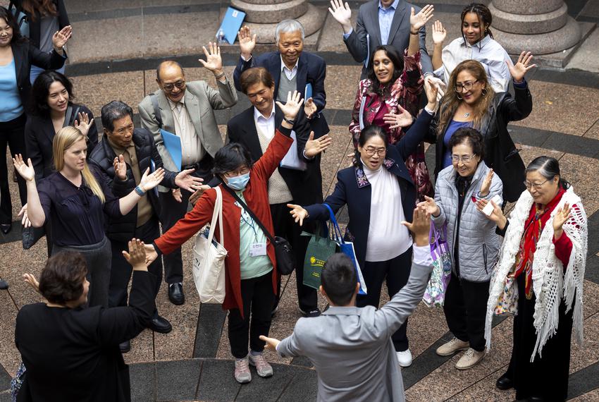 Woori Juntos Organizing and Policy Manager Steven Wu, bottom center, leads a chant with staff and supporters after a public hearing for HB5166 on Tuesday, April 25, 2023.