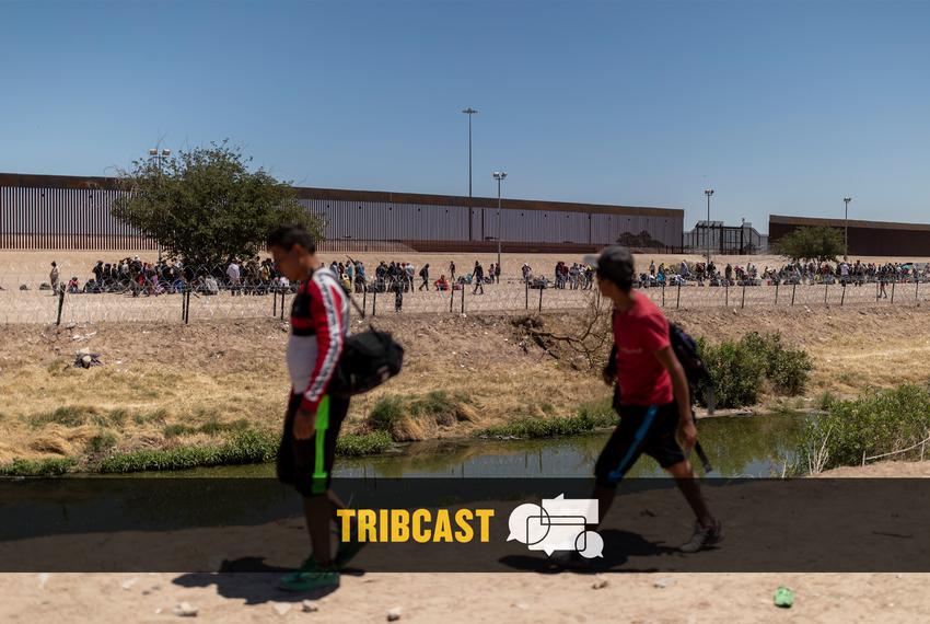 Two men walk on the banks of the Rio Grande River as several hundred migrants wait on the U.S. side to be picked up and processed by CBP on May 8, 2023 in Juarez, Chihuahua.