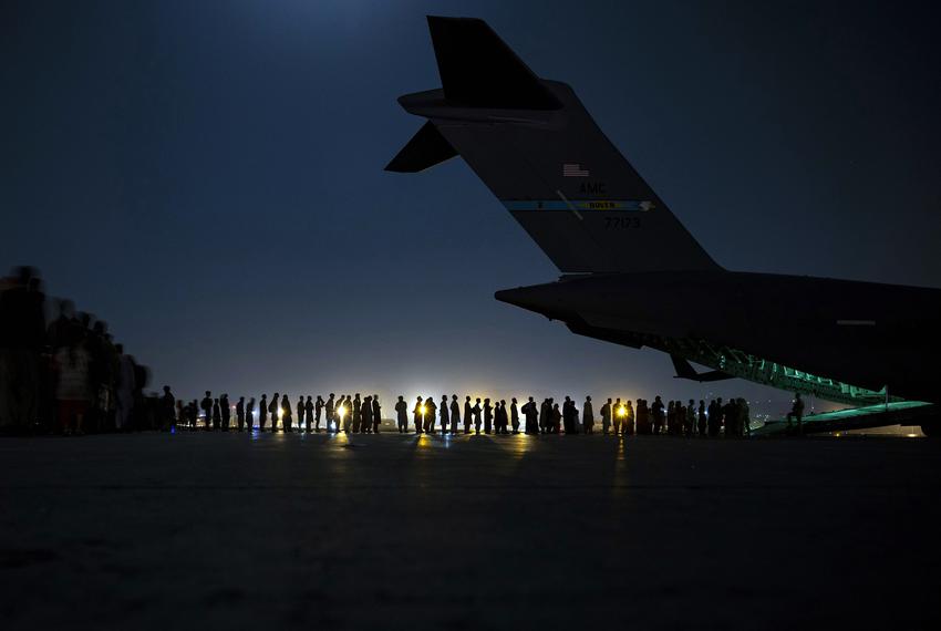 An aircrew assigned to the 816th Expeditionary Airlift Squadron prepares to load qualified evacuees aboard a U.S. Air Force C-17 Globemaster III in support of Afghanistan evacuation at Hamid Karzai International Airport in Afghanistan on Aug. 21, 2021.