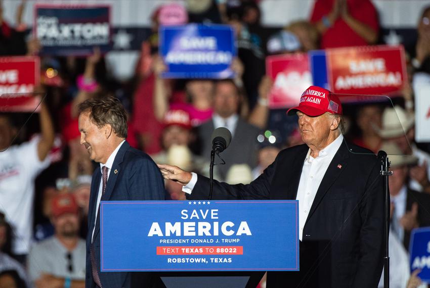 Former president Donald Trump pats Texas Attorney General Ken Paxton on the shoulder as he leaves the stage during a rally in Robstown, on Oct. 22, 2022.