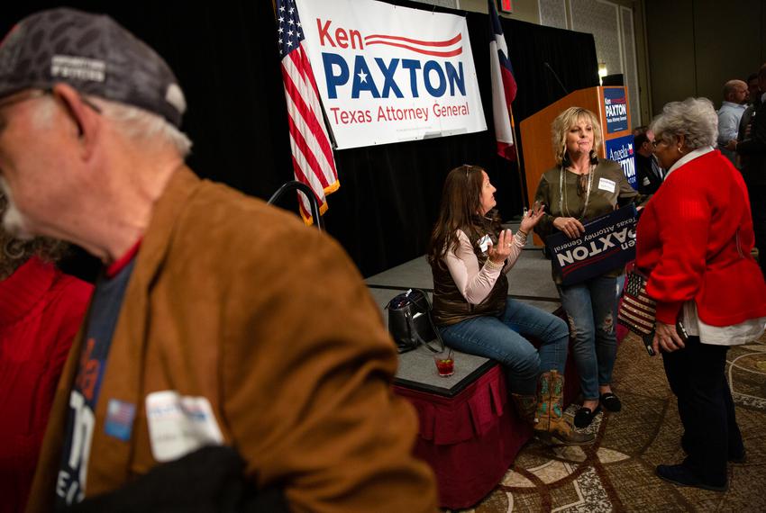Attendees of Ken Paxton’s primary election results watch party chat after Paxton spoke to the crowd in McKinney on March 1, 2022.