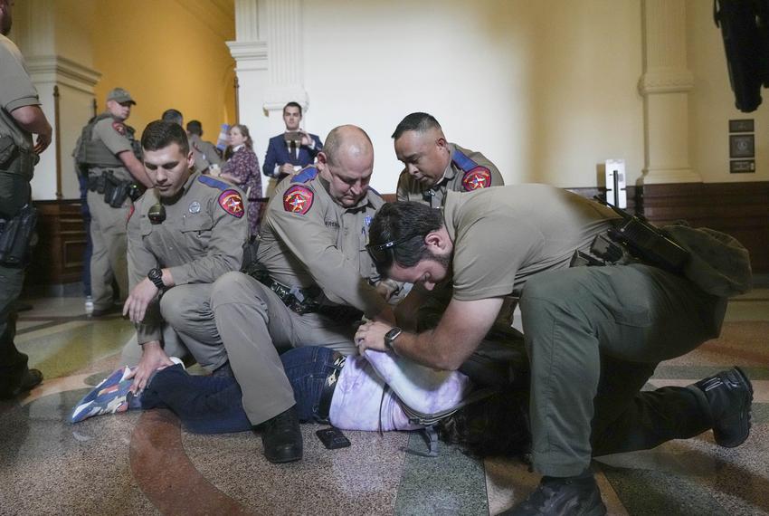 LGBTQ rights activist Adri Pérez is detained by Department of Public Safety troopers as activists protest SB 14 outside of the House of Representatives gallery at the Capitol on May 2, 2023.