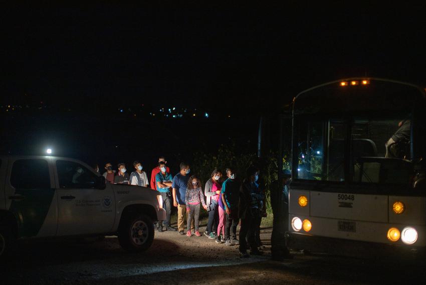 Migrants walk onto a bus after crossing the border in Roma on Aug. 16, 2021.